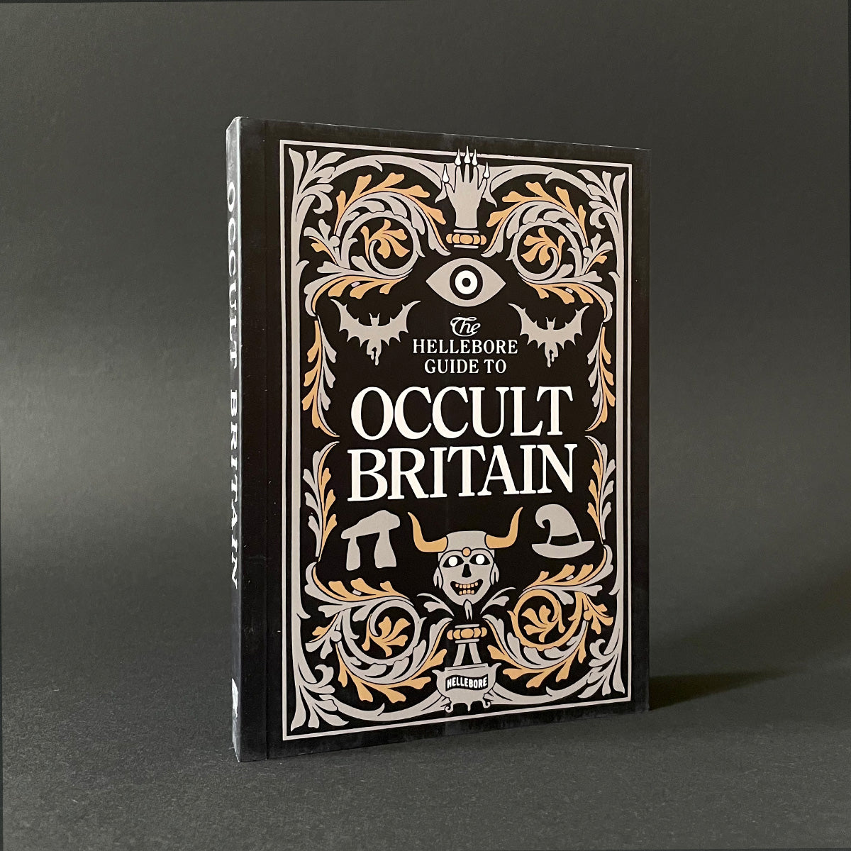 Book titled 'The Hellebore Guide to Occult Britain' with decorative cover on a dark background