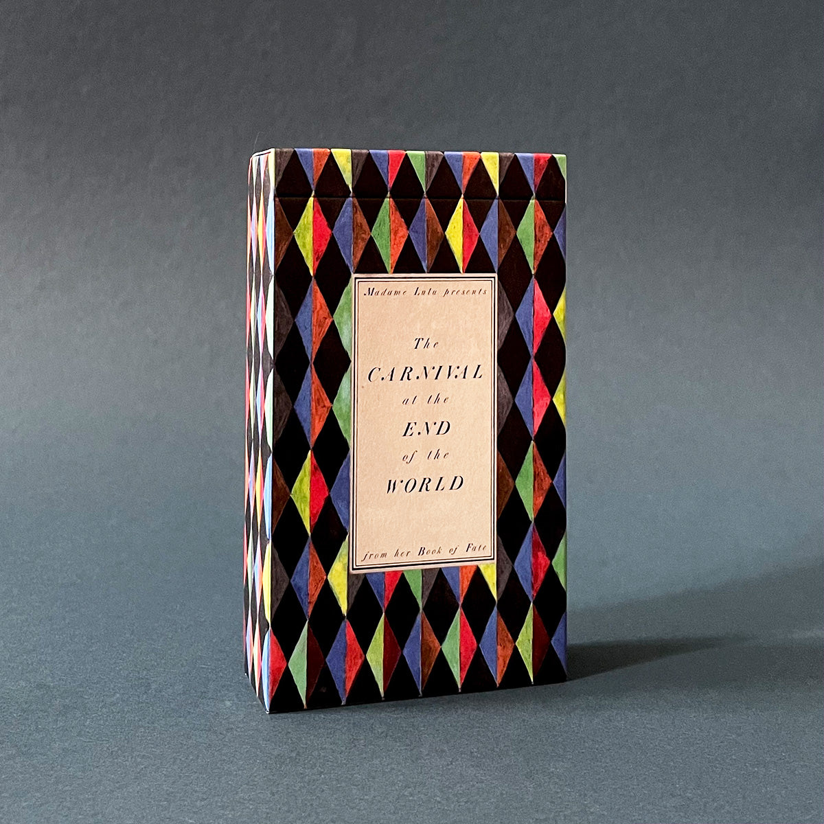 Tarot Deck with geometric pattern and 'The Carnival at the End of the World' title on a gray background