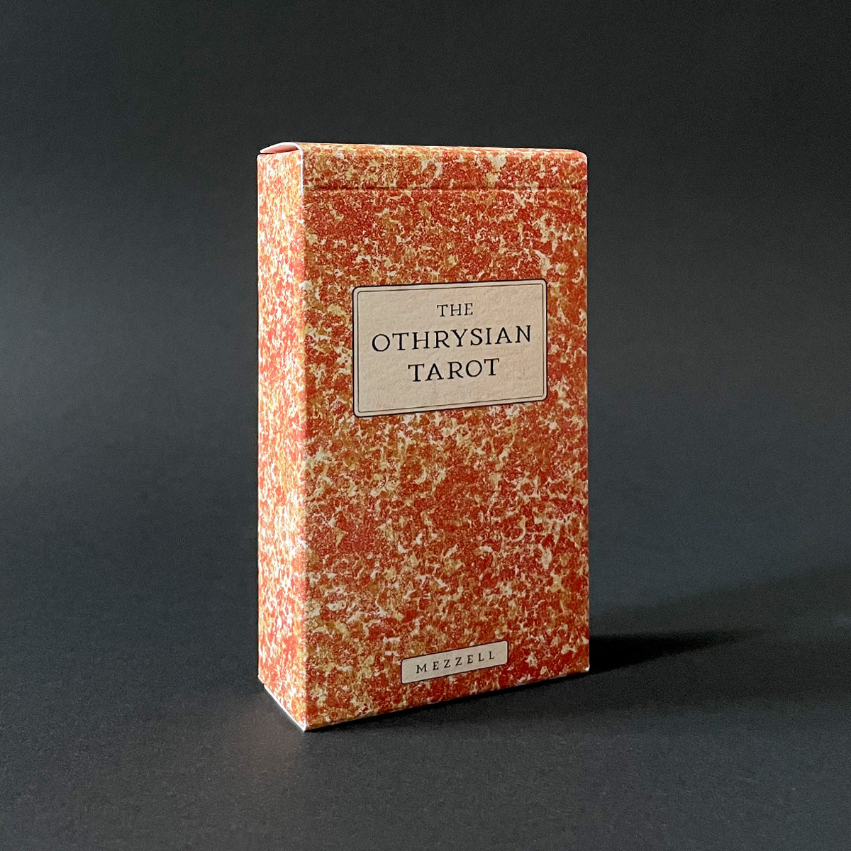 The Othrysian Tarot box with a textured red and beige design on a dark background