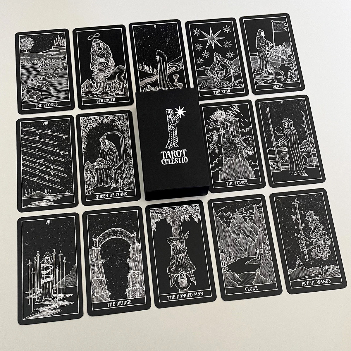 A collection of black and white hand-drawn Tarot cards laid out in a grid pattern, featuring detailed illustrations in a mystical and artistic style.