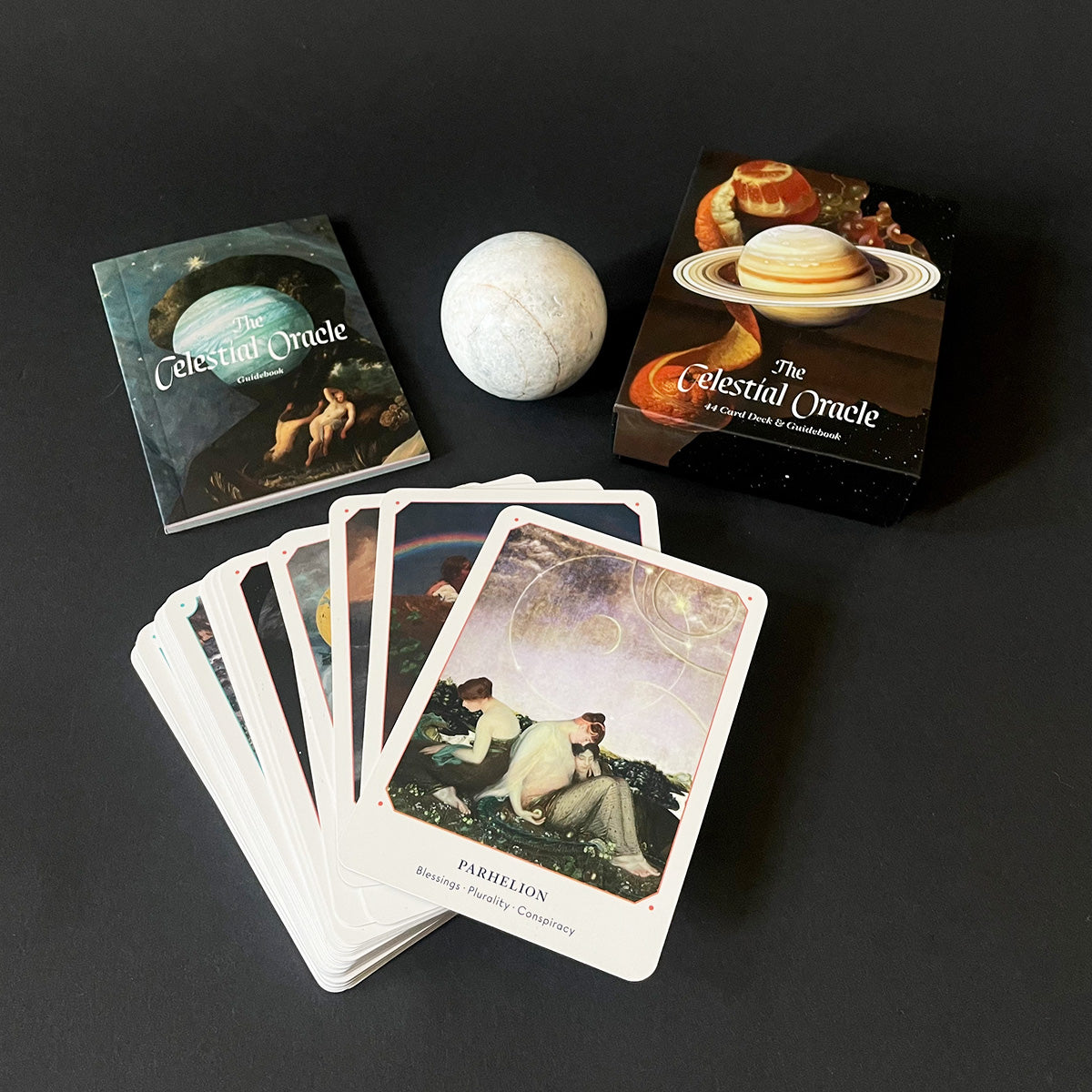 Set of 'Celestial Oracle' cards with a spherical object on a dark background
