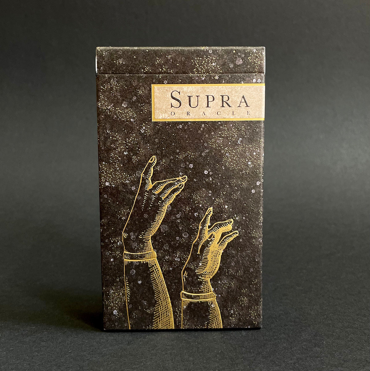 An oracle deck titled "Supra" with box displaying embossed gold hands against a dark background.