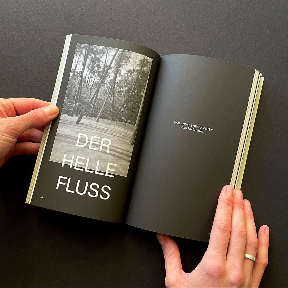 Open book with black cover and white text on a dark background