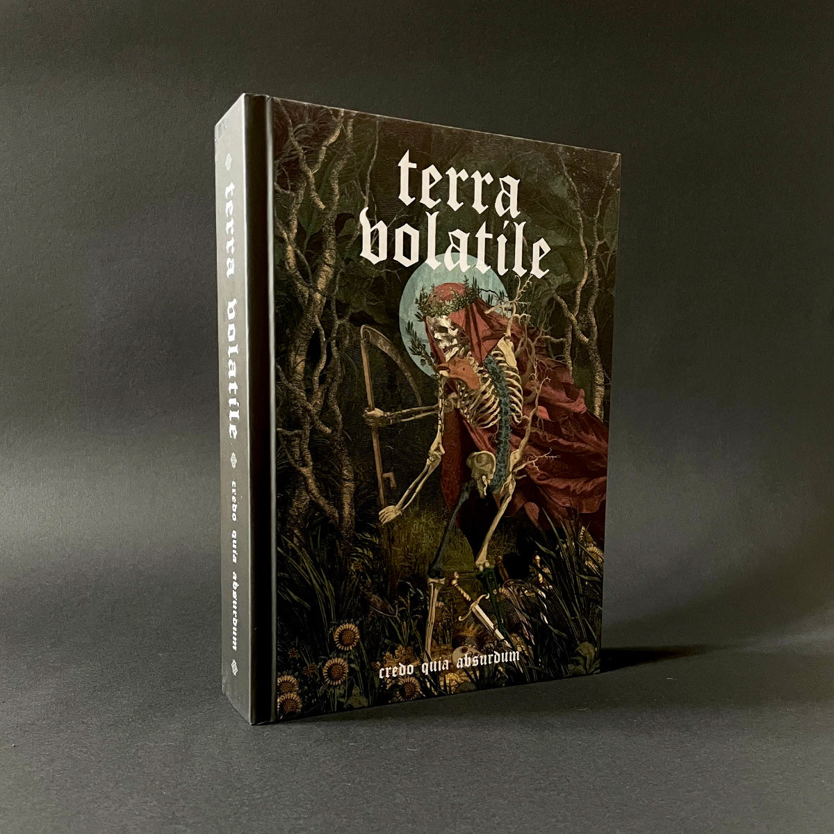 Book titled 'terra volatile' with a skeleton and nature design on a dark background